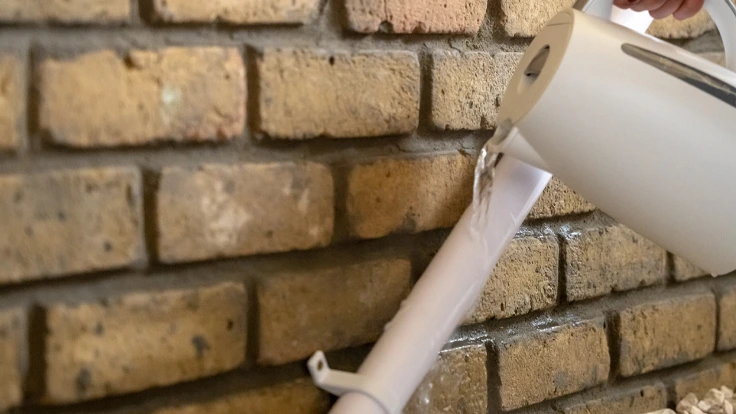 Frozen condensate pipe on an outside wall in winter